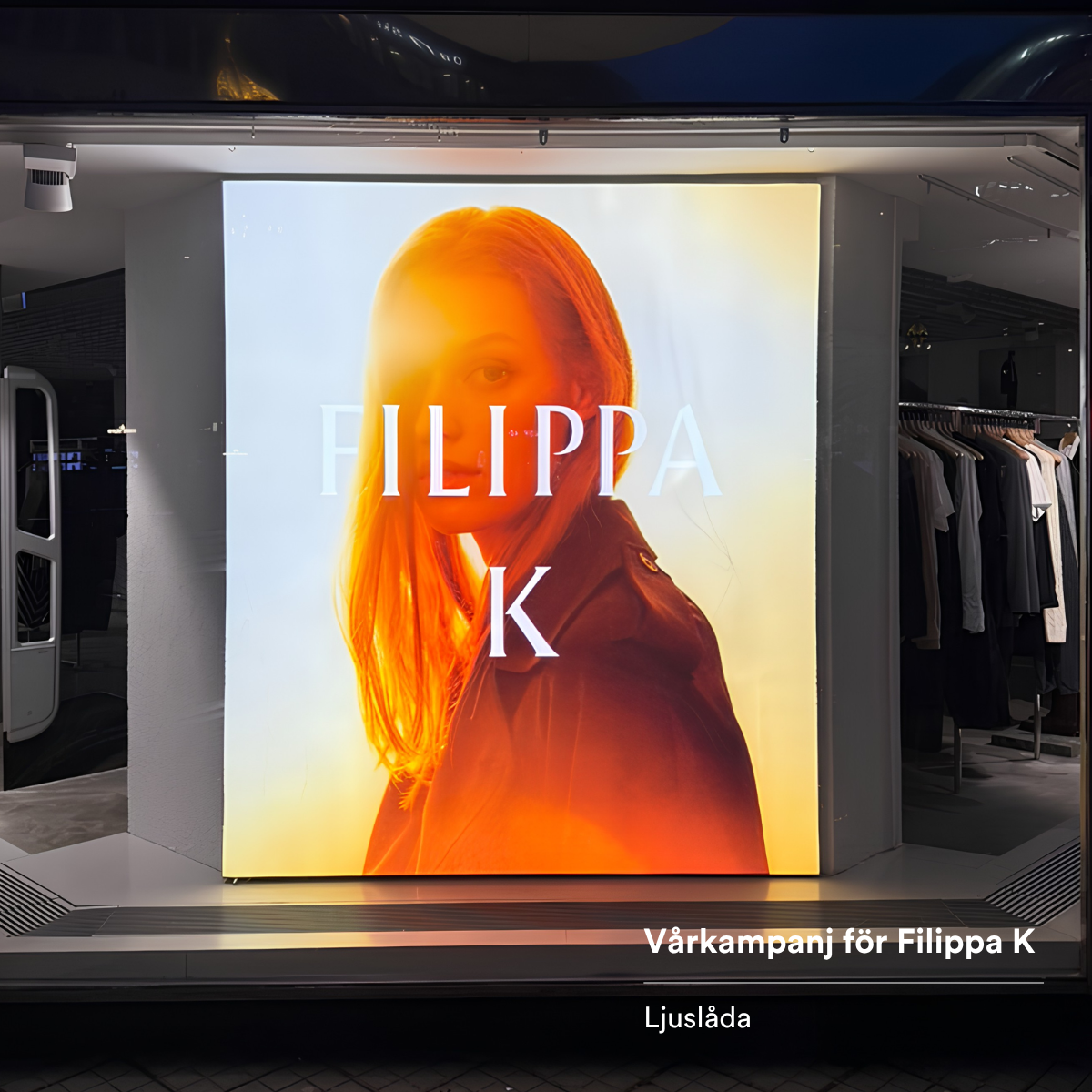 Backlit storefront poster featuring a woman in warm orange glow with 'FILIPPA K' text across the image, advertising a spring campaign.