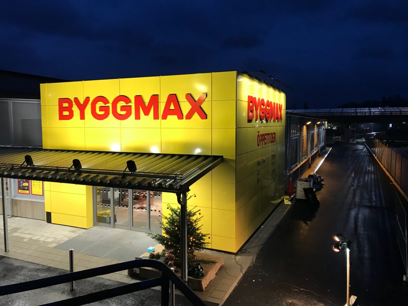 BYGGMAX storefront at night with a bright yellow facade and large red lettering.